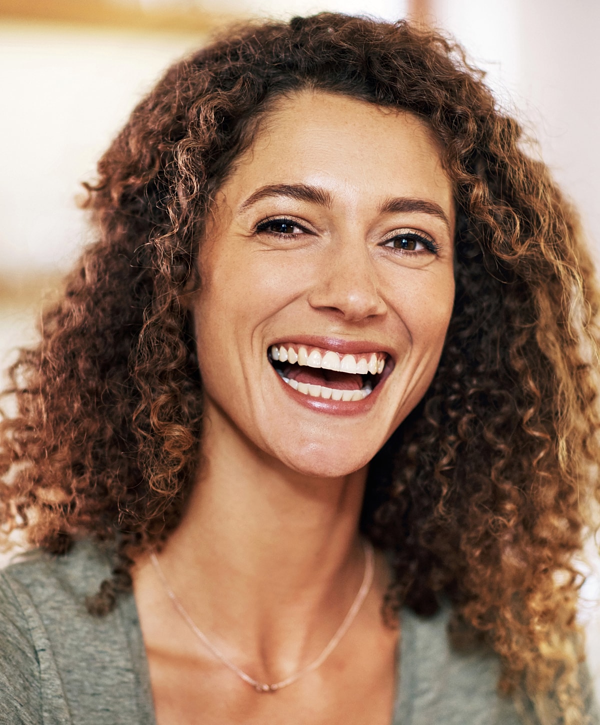 Smiling woman with curly hair and joyful expression